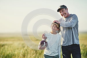 Father, kid fun and rugby portrait in a countryside field for bonding in nature. Mockup, dad and young boy child