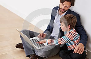 Father, kid and laptop on floor for learning, online education and teaching boy at home. Child, dad and computer for