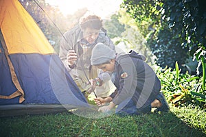 Father, kid and preparing tent for camping outdoor in nature on vacation while bonding in summer sunset. Dad, boy and