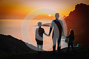 Father with kids-boy and girl- travel in sunset mountains, family travel