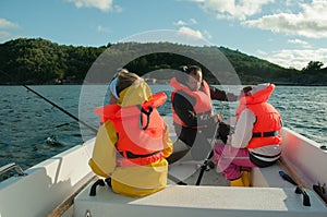 Father and kids fishing in a boat