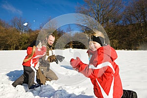 Father with kids having a snowball fight in winter