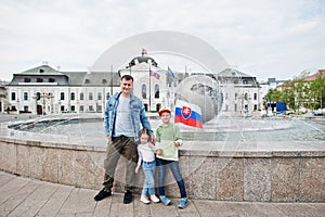 Otec s deťmi držiaci vlajku v Grassalkovichovom paláci, Bratislava, Európa. Sídlo prezidenta SR v Bratislave