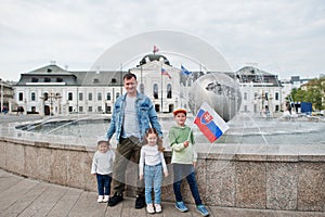 Otec s dětmi drží vlajku v Grassalkovichově paláci, Bratislava, Evropa. Rezidence prezidenta Slovenska v Bratislavě