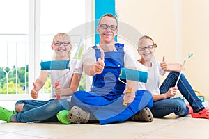 Father and Kids paint a wall in home