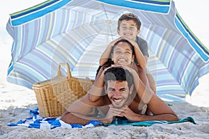 Father, kids and smile in portrait on beach, summer vacation with parasol, bonding and love. People outdoor, holiday in