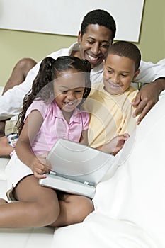 Father With Kids Watching Movie On Portable DVD Player