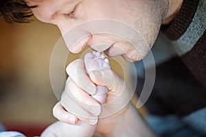 Father kissing foot of newborn baby.