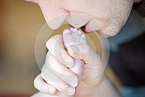 Father kissing foot of newborn baby.