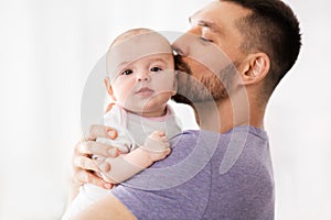 Father kissing little baby daughter