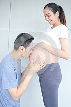 Father kissing pregnant mother`s belly. Man kissing the belly of his lovely pregnant wife