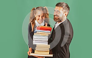 Father leading his pupil daughter to school. Portrait of modern family dad and little girls isolated on green blackboard