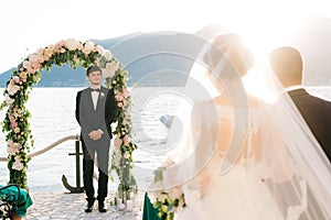 Father leads the bride to the altar, where the groom is waiting for her