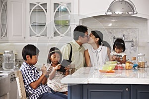 Father Leaving For Work After Family Breakfast In Kitchen