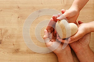 Father and little child holding together wooden heart. Happy father`s day concept