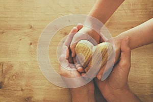 Father and little child holding together wooden heart. Happy father`s day concept