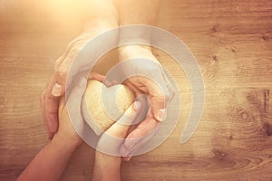 Father and little child holding together wooden heart. Happy father`s day concept