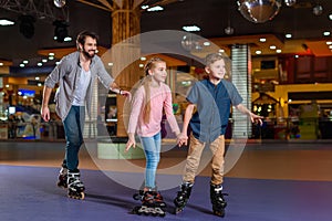 father and little children skating together