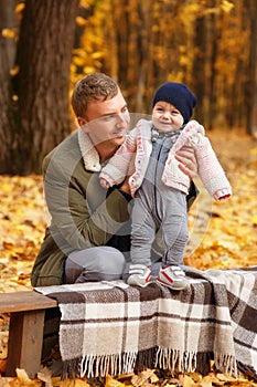 Father with a little daughter in autumn park