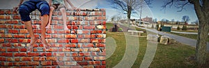 Father and little daughter sitting on brick wall in a park / father`s day