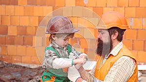 Father and little son with drill perforating wood plank at workshop. Father and son. Cute boy building house. Father and