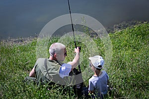 Father and little son fishing on the lake.
