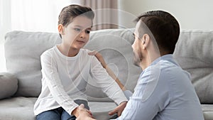 Father and little son having heart to heart talk indoors