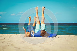 Father and little son play on beach