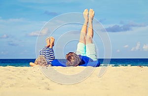 Father and little son play on beach