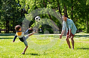 Father with little son playing soccer at park