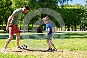 Father with little son playing soccer at park