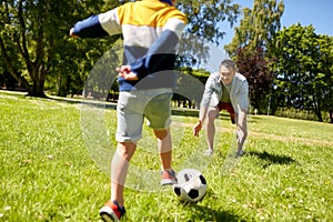 Father with little son playing soccer at park