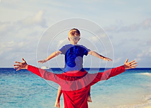 Father and little son on shoulders play at sky