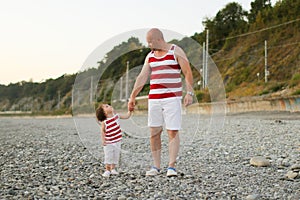 Father and little son in similar clothes look at together