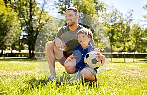 Father and little son with soccer ball at park