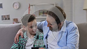 Father and little son spending time together, playing games on smartphone, wifi