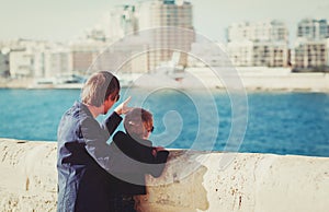 Father and little son travel in the city looking at modern buildings