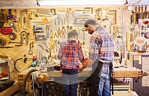 Father and little son with wood plank at workshop