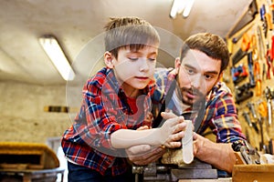 Father and little son with wood plank at workshop