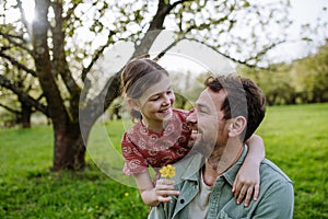 Father looking at his daughter lovingly in spring nature. Father's day concept. photo