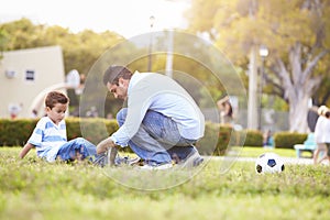 Father Looking After Son Injured Playing Football