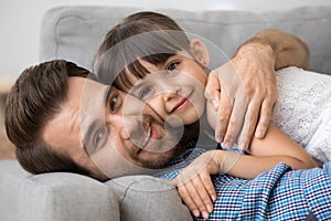 Father lying hugging with lovely daughter at home