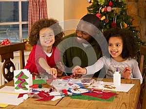 Father making Christmas cards with children
