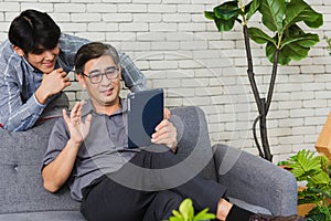 Father man and his son sit on sofa talking chatting on video call