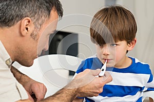 Father Measuring Temperature Of His Son