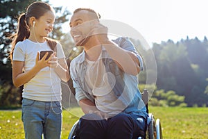 Father with mobility impairment listening to music with daughter