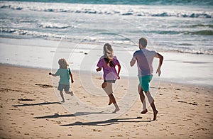 Father, mother and child running jogging on the beach. Concept healthy family lifestyle. Summer people vacation at sea.