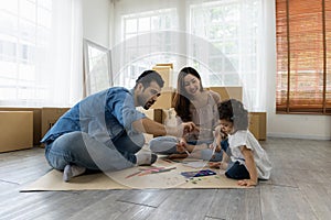 Father Mother and daughter drawing and painting coloring with watercolor lying down on the floor. Happy family moment in the house