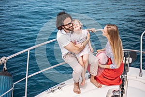 Father, mother and daughter sailing on yacht at the sea