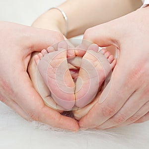 Father and mother holding feets of newborn